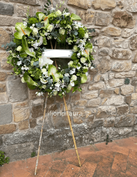 Corona funebre con fiori freschi assortiti, colori tenui.